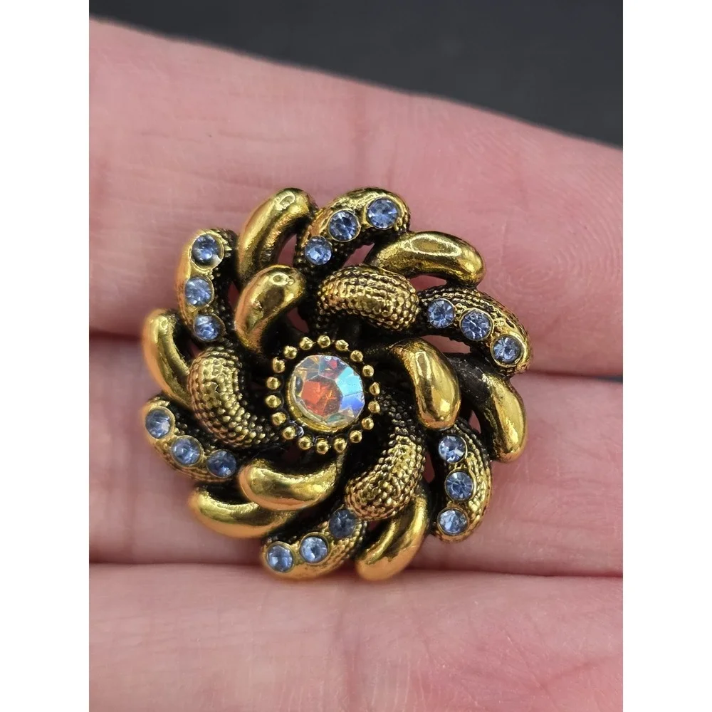 gold-toned vintage style flower brooch with blue and iridescent rhinestones